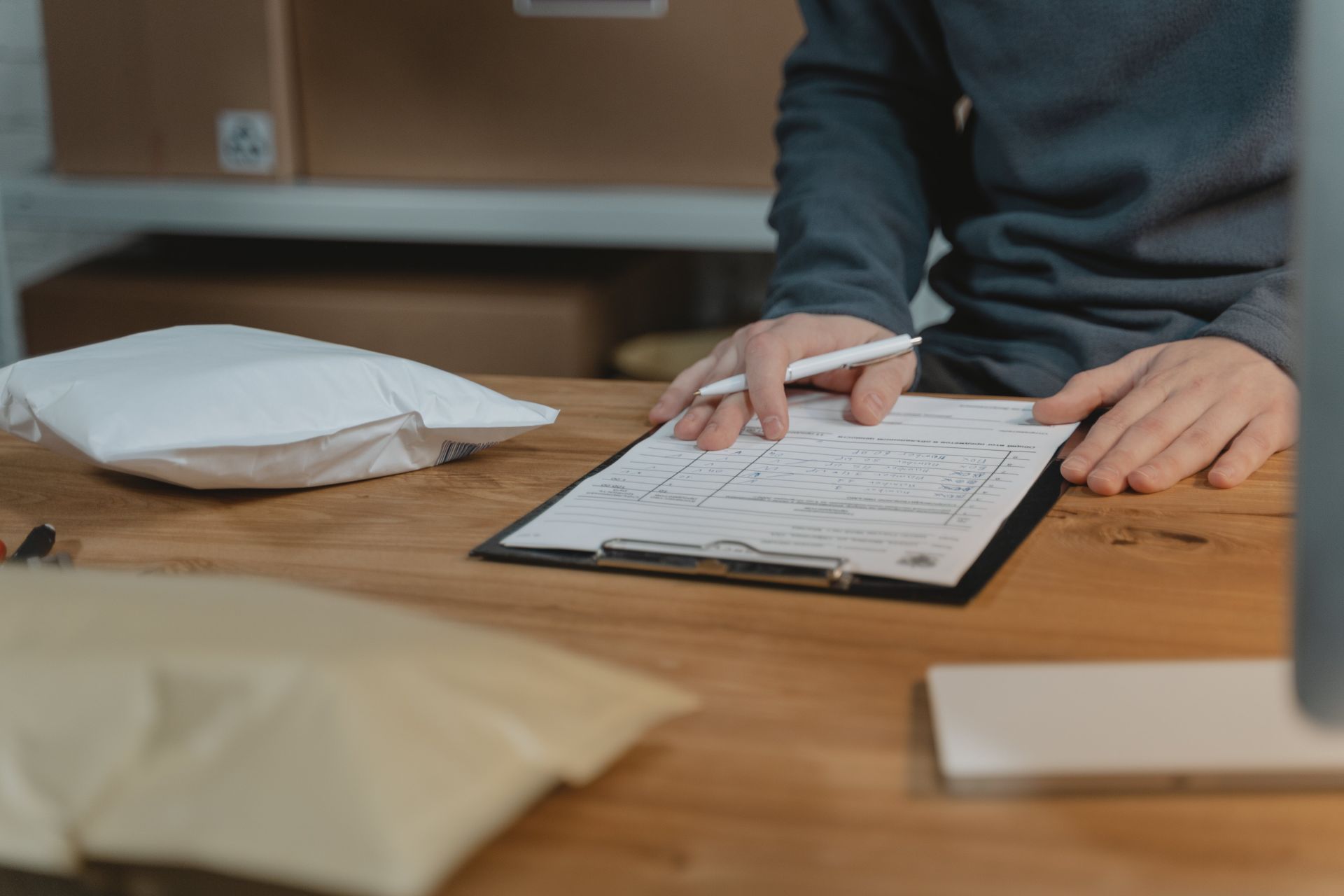 Person in Gray Long Sleeve Shirt Writing on White Paper